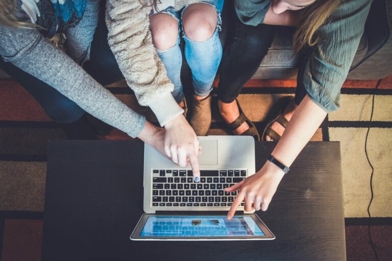 3 women pointing at a laptop screen Defining roles and responsibilities